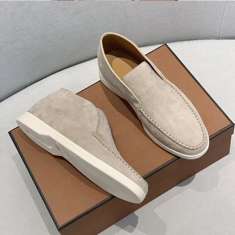 Chaussures mocassins en daim beige sur boîte marron, design élégant et moderne, parfaites pour un style décontracté et chic.