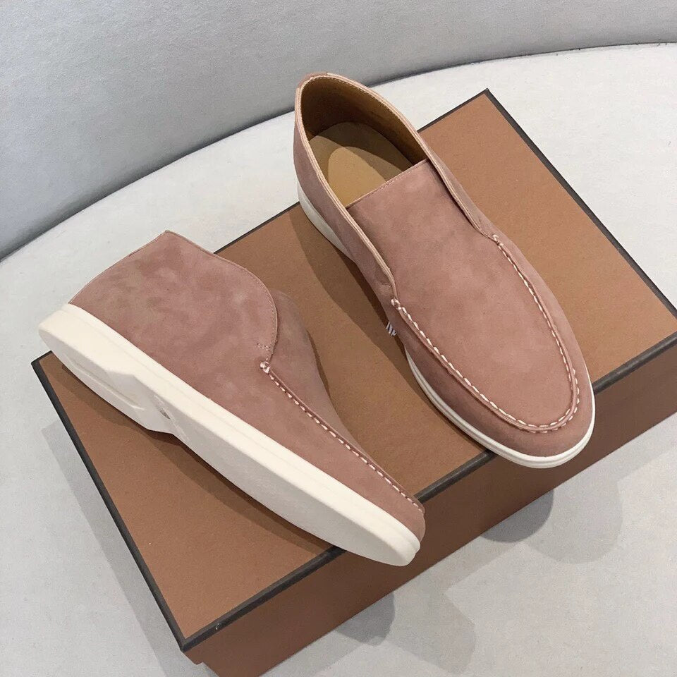 Chaussures mocassins en daim rose sur boîte marron, semelles blanches, style élégant et moderne, parfaites pour mode masculine décontractée.