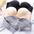 Soutiens-gorge sans bretelles en noir, beige et gris, avec fermeture à agrafes, posés sur une surface blanche. Lingerie féminine confortable et élégante.