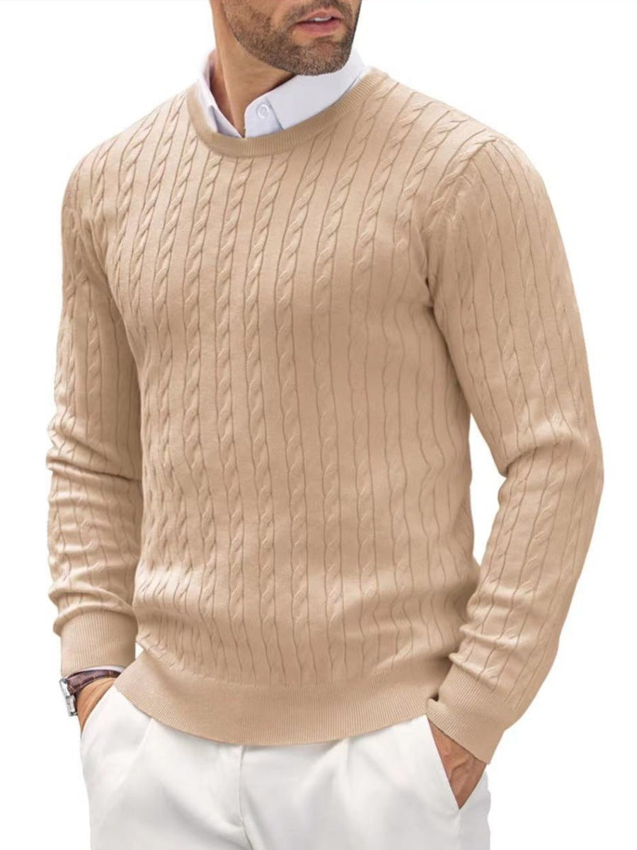 Homme portant un pull beige torsadé, manches longues, sur une chemise blanche, style élégant et décontracté, mode masculine automne-hiver.