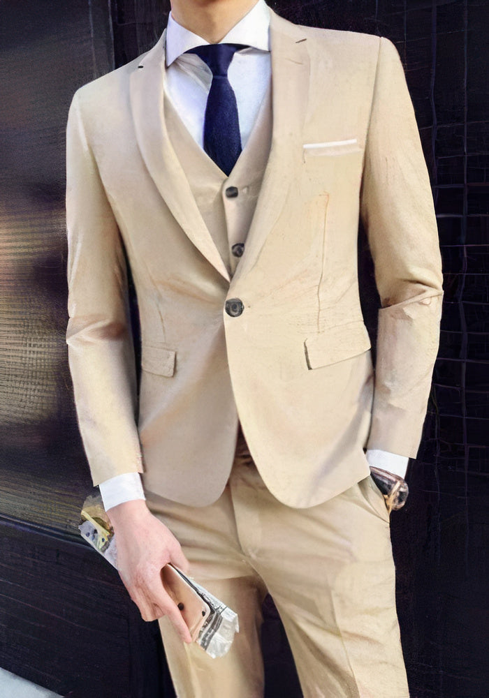 Homme en costume beige élégant, cravate bleue, tenant un smartphone. Mode masculine, tenue formelle, style moderne.
