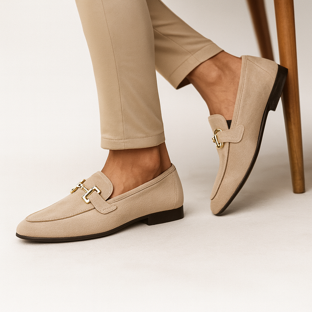 Chaussures mocassins beige élégantes pour femme, en cuir, avec boucle dorée, portées avec un pantalon beige. Mode féminine chic et tendance.