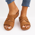 Sandales en cuir marron pour femme, avec motifs perforés, portées avec un jean. Chaussures d'été confortables et élégantes.