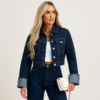 Femme portant une veste en jean bleu foncé, chemise blanche et pantalon assorti, tenant un sac à main blanc. Mode tendance, style décontracté.