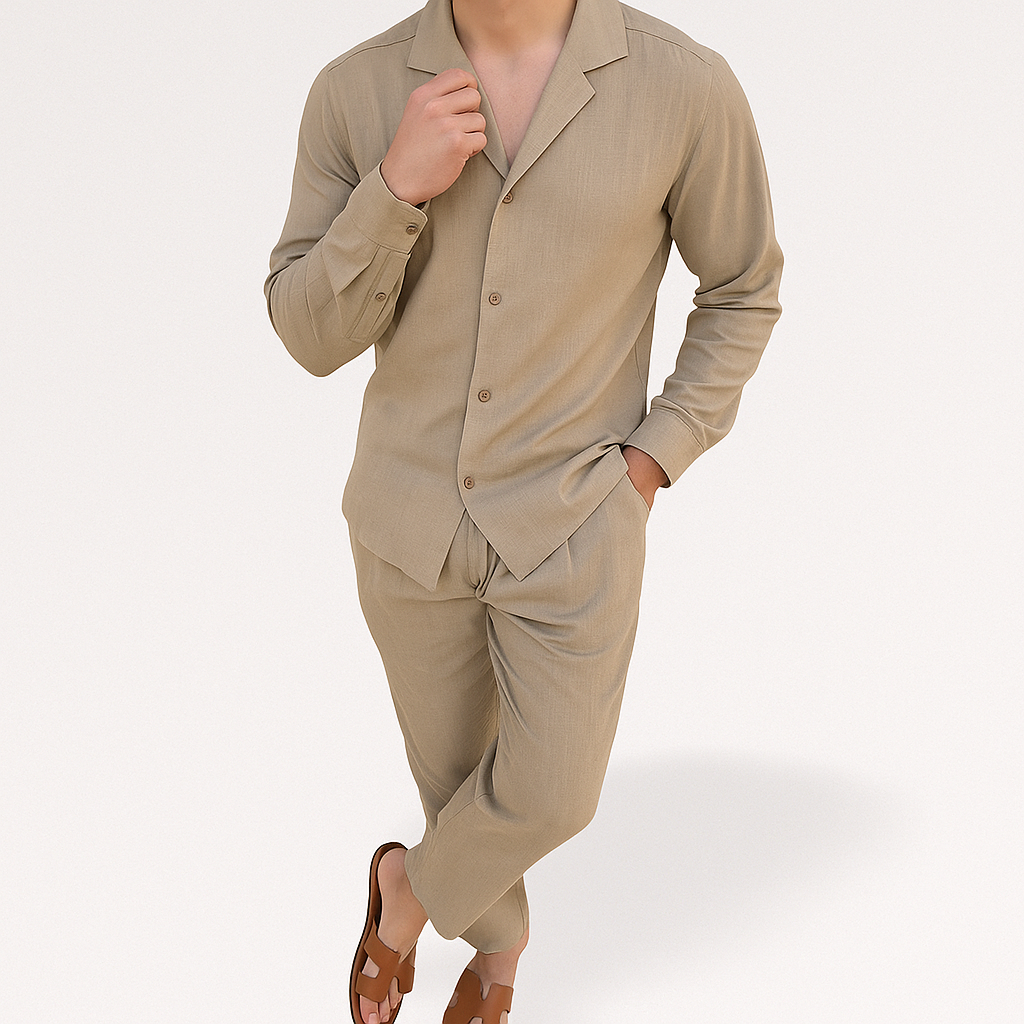 Homme en costume beige élégant, chemise à col ouvert, pantalon assorti, sandales marron, pose décontractée. Mode masculine moderne, style chic.