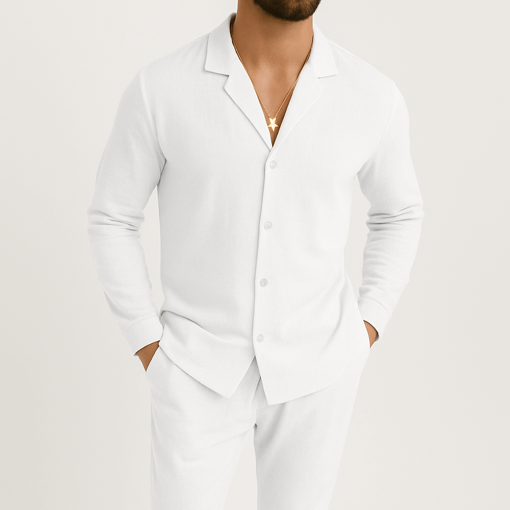 Homme portant une chemise blanche élégante avec un collier doré, mains dans les poches, style décontracté chic, mode masculine moderne.