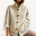 Gilet en laine beige avec boutons en bois, porté sur une chemise blanche. Mode automne-hiver, style décontracté et élégant.