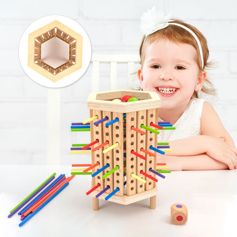Enfant souriant jouant avec un jeu éducatif en bois, bâtonnets colorés et dés, favorisant la motricité et la coordination. Jouet éducatif pour enfants.