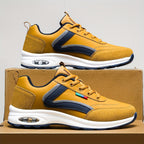 Chaussures de sport jaunes avec semelle blanche, détails en cuir bleu marine, posées sur une boîte en carton. Design moderne et confortable.