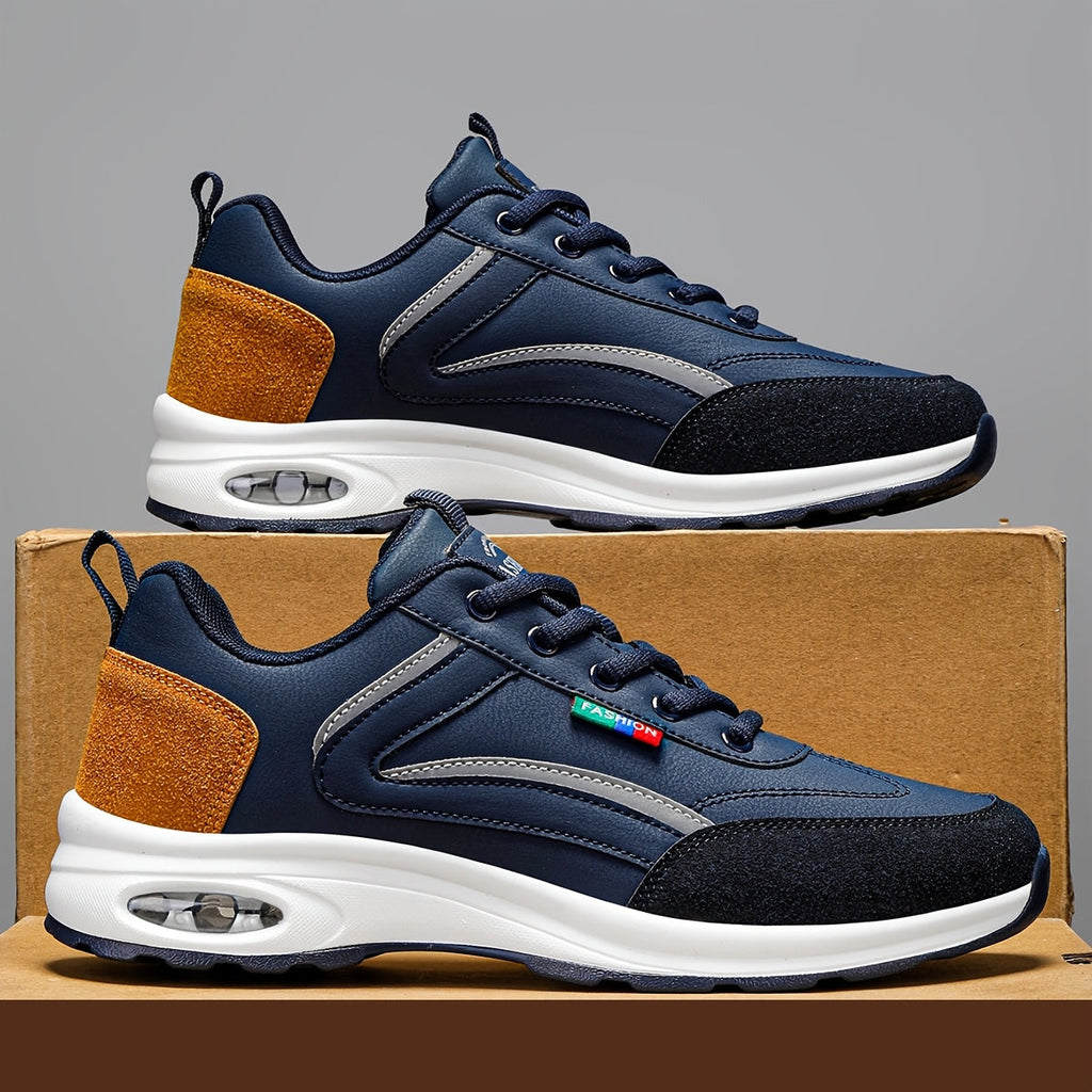 Chaussures de sport bleu marine avec semelle blanche, détails orange et noir, posées sur une boîte en carton. Design moderne et confortable.