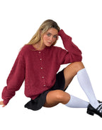 Femme portant un pull rouge texturé, jupe noire, chaussettes hautes blanches et chaussures noires. Mode automne, style décontracté chic.