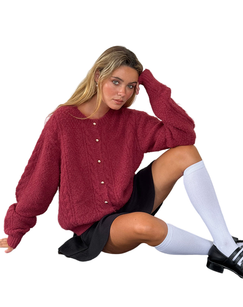 Femme portant un pull rouge texturé, jupe noire, chaussettes hautes blanches et chaussures noires. Mode automne, style décontracté chic.