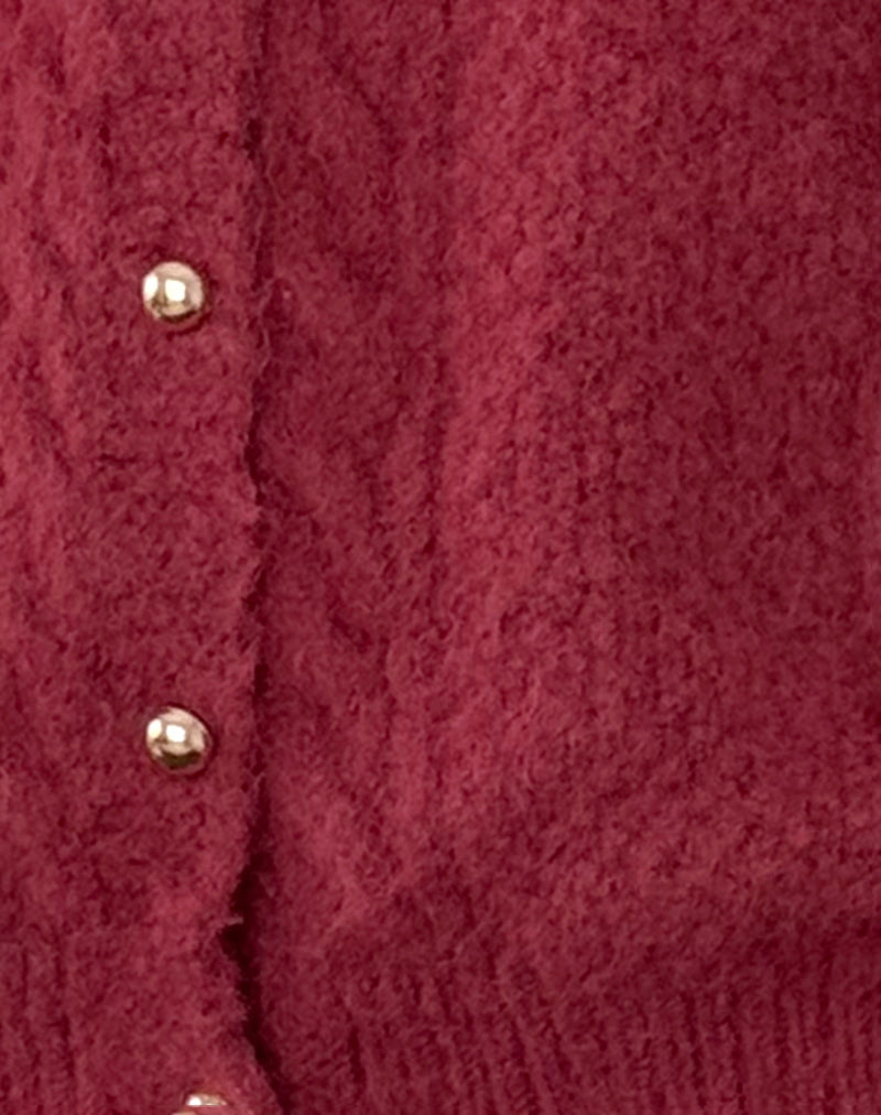 Cardigan en laine rouge avec boutons dorés, texture douce et chaude, mode automne-hiver, vêtement élégant pour femme, style chic et confortable.