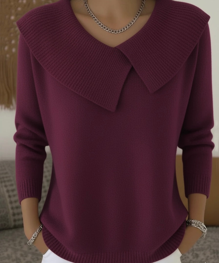 Pull-over en laine bordeaux avec col large, manches longues, porté par une personne. Accessoires argentés. Mode automne-hiver élégante et tendance.