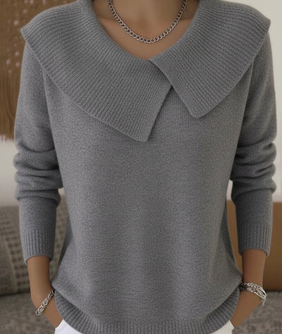 Pull gris élégant avec col large en tricot, manches longues, porté par une personne. Mode automne, style chic et moderne, tendance vêtements femme.