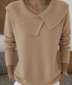 Pull beige élégant avec col large en tricot, manches longues, porté par une personne. Mode automne, style chic et confortable.