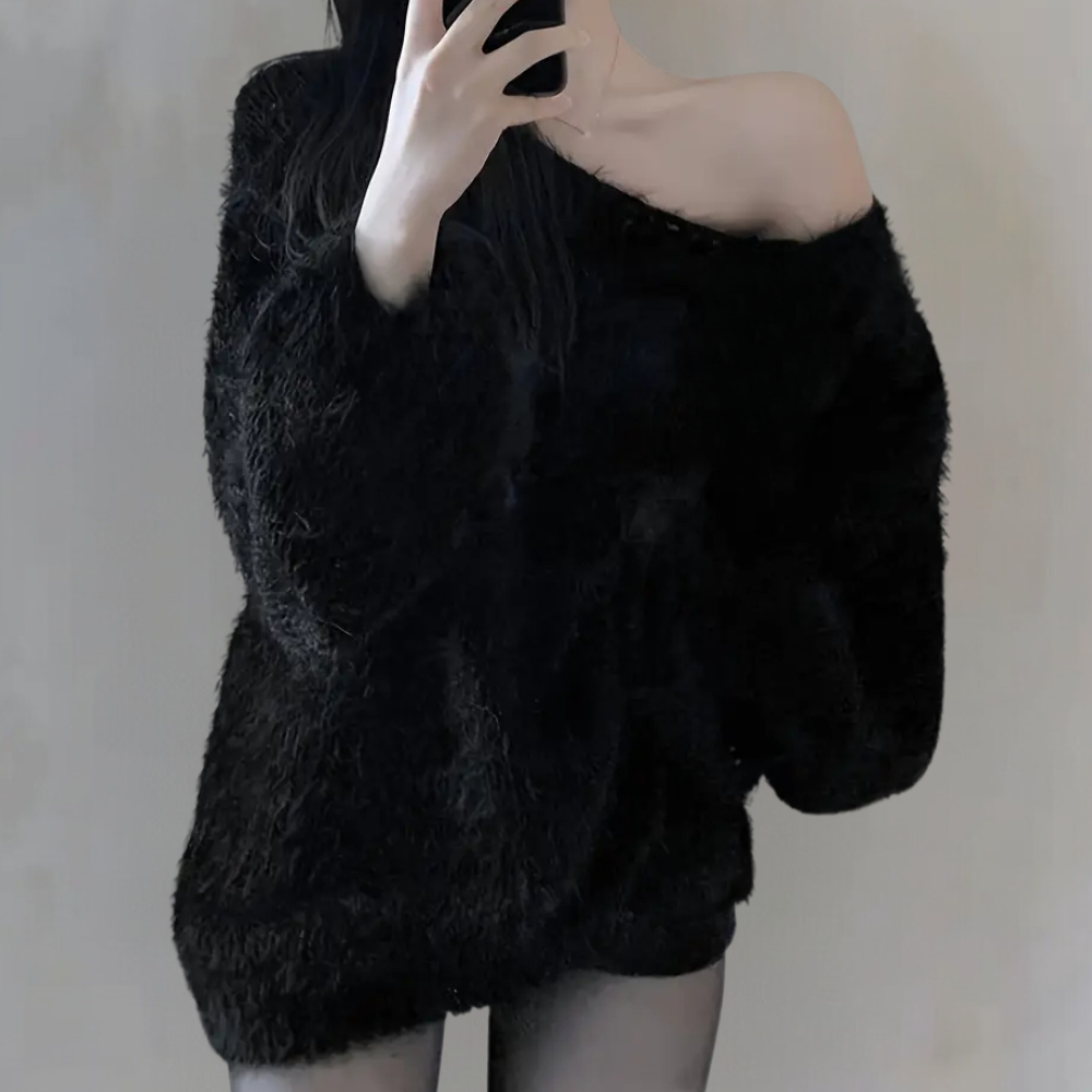 Femme en pull noir en laine, épaules dénudées, prenant un selfie. Mode hiver, style décontracté, tendance vêtements chauds.