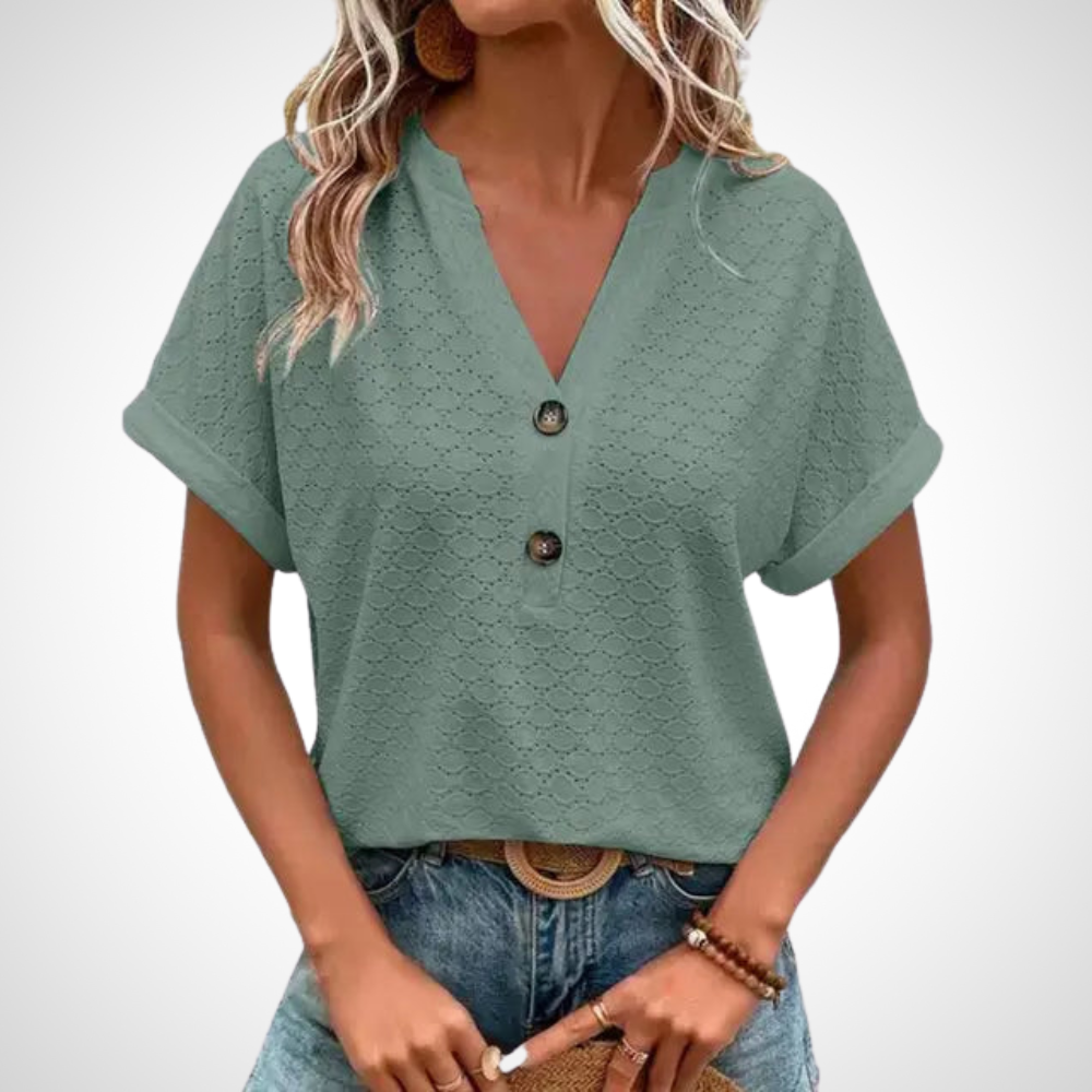 Femme portant un chemisier vert à manches courtes avec boutons, associé à un jean bleu. Mode décontractée, style estival, tendance féminine.