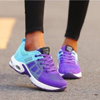 Baskets de sport violettes et bleues pour femme sur route, design moderne, confortables, idéales pour course à pied et fitness.