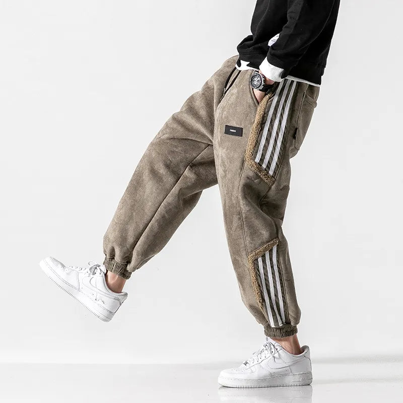 Pantalon cargo marron pour homme avec bandes blanches, style décontracté, porté avec des baskets blanches. Mode urbaine tendance.