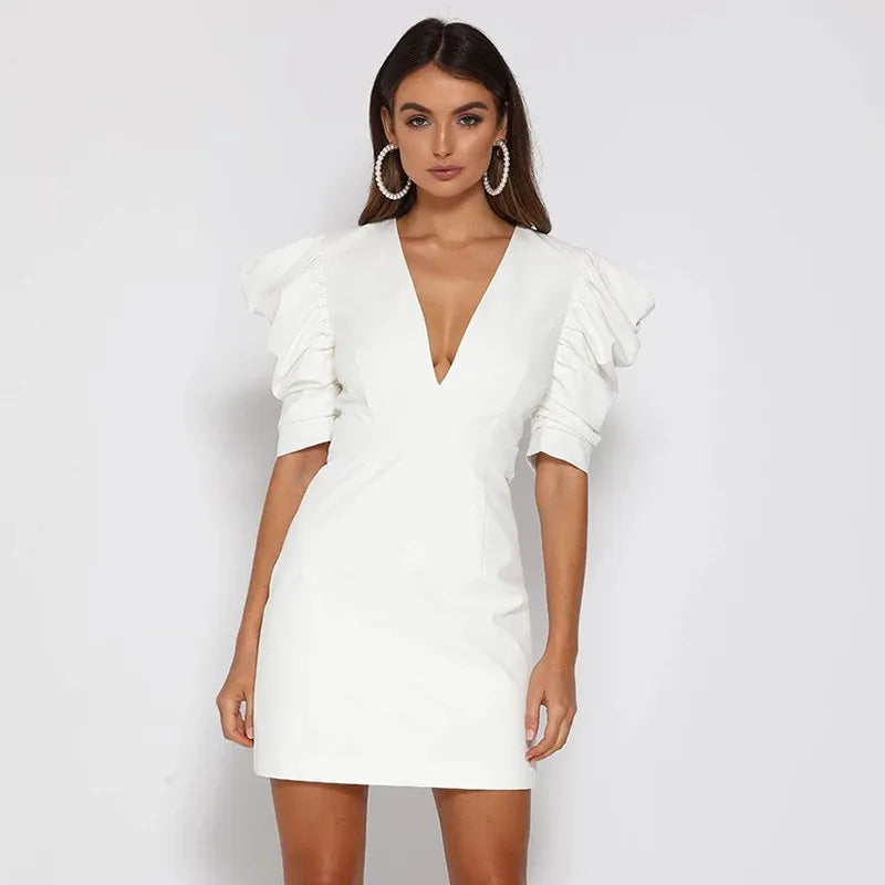 Robe blanche élégante à manches bouffantes, décolleté plongeant, portée par une femme. Mode féminine chic, tendance soirée, style moderne.
