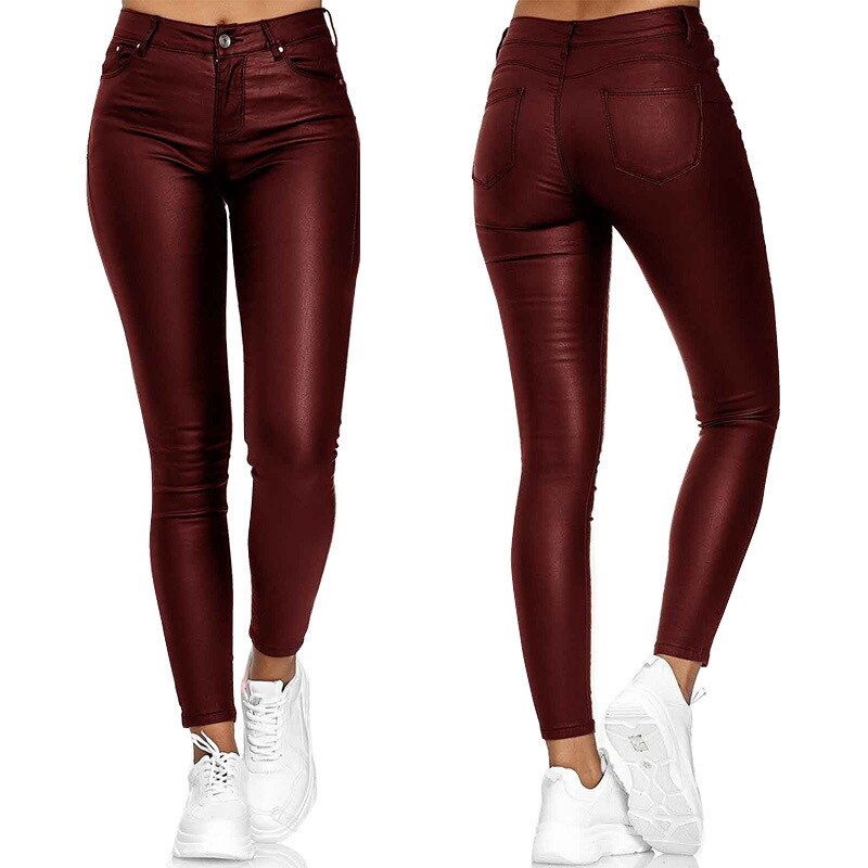 Pantalon en cuir bordeaux pour femme, coupe slim, taille haute, avec poches arrière, porté avec des baskets blanches. Mode féminine tendance.