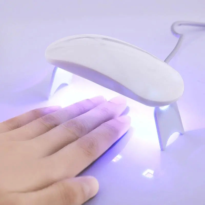 Séchoir à ongles LED UV blanc, manucure gel, main sous lampe, séchage rapide, outil beauté, nail art, technologie moderne, salon à domicile.