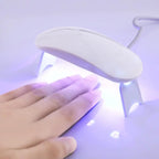 Séchoir à ongles LED UV blanc, manucure gel, main sous lampe, séchage rapide, outil beauté, nail art, technologie moderne, salon à domicile.