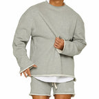 Homme portant un ensemble décontracté gris, sweat-shirt et short assortis, style moderne et confortable, mode masculine tendance.
