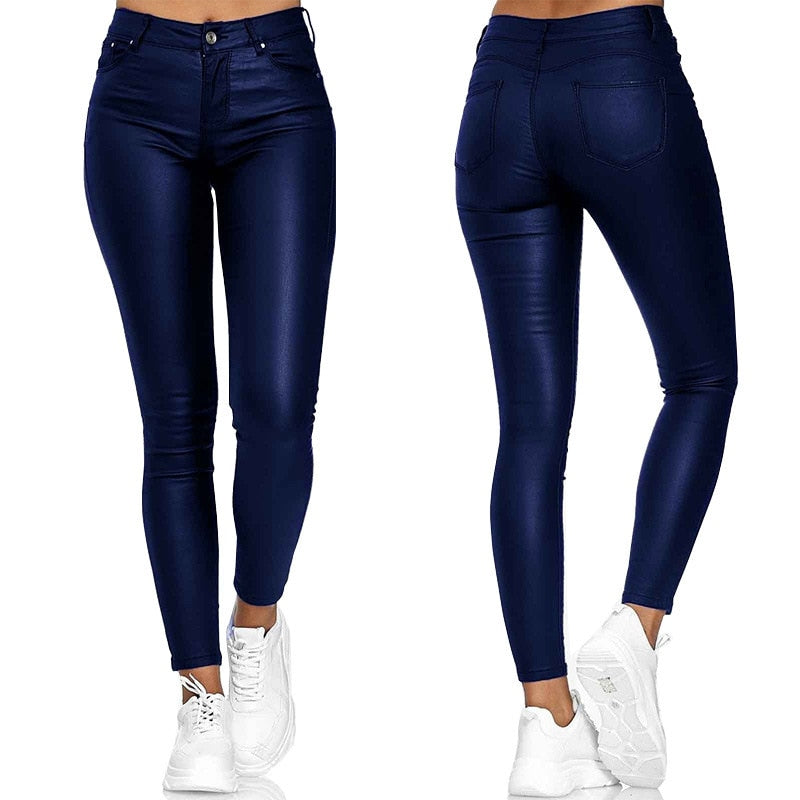 Jean skinny bleu foncé pour femme, taille haute, avec poches arrière, porté avec des baskets blanches. Mode féminine, pantalon tendance.