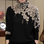 Pull noir à col roulé avec motif floral beige, élégant et moderne, idéal pour l'automne. Mode féminine chic, tendance et confortable.
