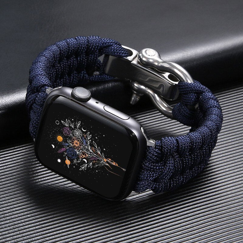 Montre connectée avec bracelet en paracorde bleu, écran affichant un motif floral. Accessoire moderne, technologie portable élégante.
