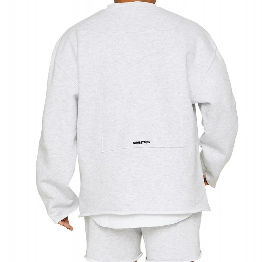 Homme portant un sweat-shirt gris clair de dos, style décontracté, avec inscription "Dumbstruck". Mode urbaine, vêtements tendance, look moderne.