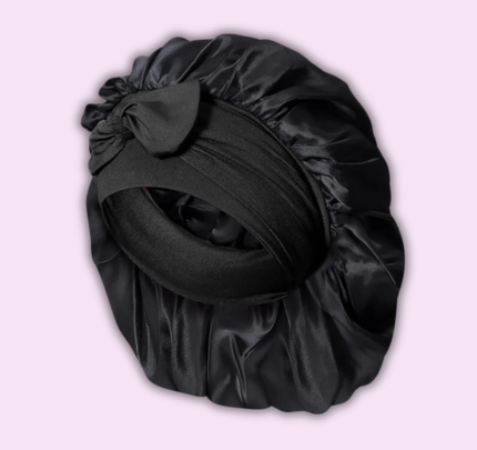 Bonnet de nuit en satin noir avec nœud décoratif, idéal pour protéger les cheveux pendant le sommeil. Accessoire capillaire élégant et pratique.