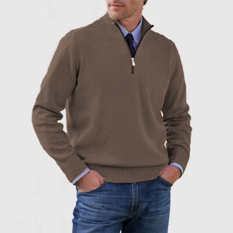 Homme portant un pull marron à col zippé, chemise bleue et jean. Mode masculine élégante, tenue décontractée automne-hiver.