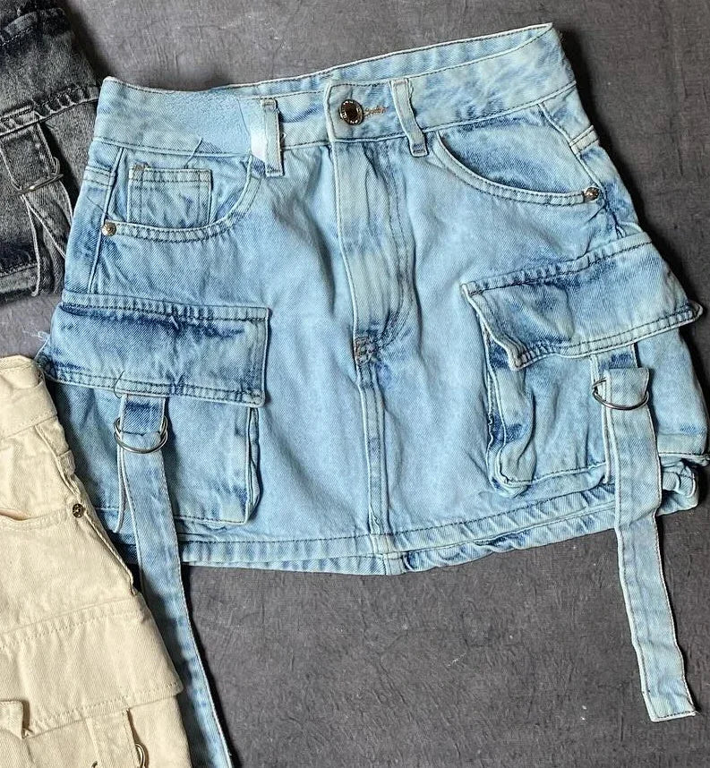 Mini-jupe en jean bleu clair avec poches cargo et ceinture, style décontracté, mode tendance, vêtement féminin, fond gris.