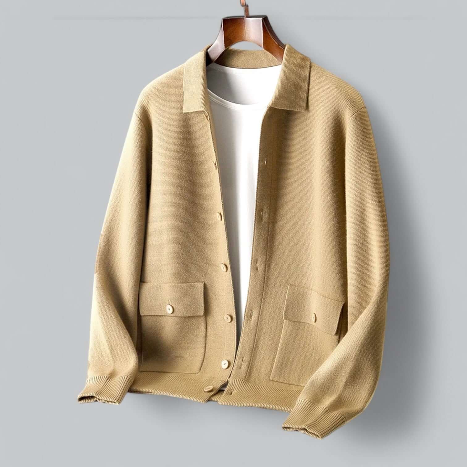 Cardigan beige en laine avec boutons, poches avant, suspendu sur cintre, fond gris. Mode automne-hiver, vêtement chaud et élégant.