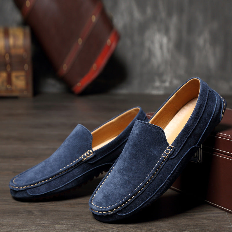 Mocassins en daim bleu pour homme sur fond en bois, élégants et confortables, parfaits pour un style décontracté ou formel.