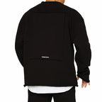 Homme portant un sweat-shirt noir oversize avec un design minimaliste, marque Dumbstruck visible, style urbain moderne.