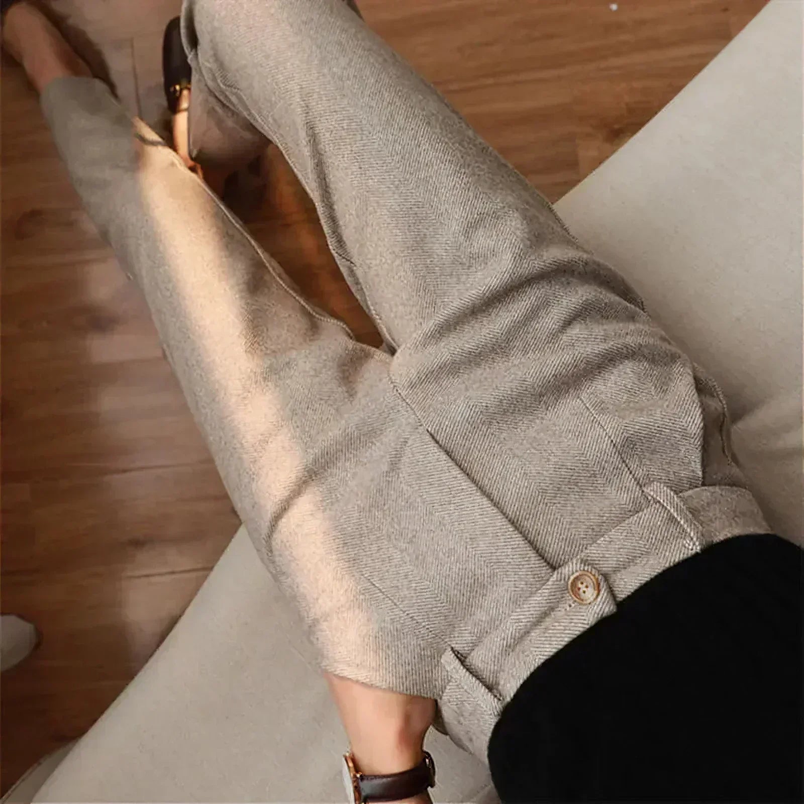 Pantalon en laine beige pour femme, coupe droite, style élégant, sur fond de parquet en bois. Mode automne-hiver, tenue chic et confortable.