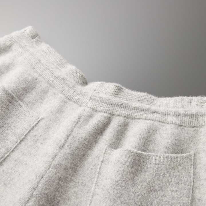 Pantalon en laine gris clair avec poches avant, texture douce et confortable, mode automne-hiver, vêtement chaud et élégant pour femmes.