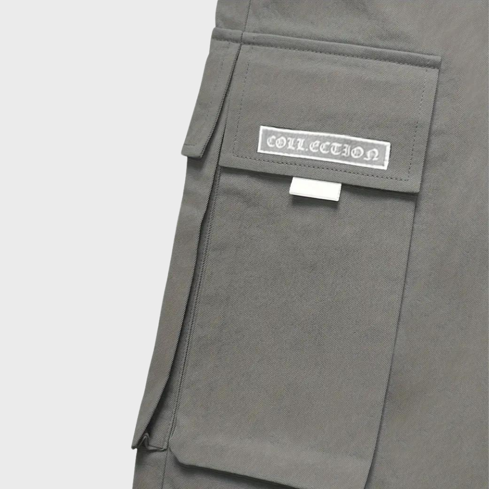 Poche de pantalon cargo gris avec rabat et étiquette "Collection", style utilitaire moderne, mode urbaine tendance, tissu résistant.