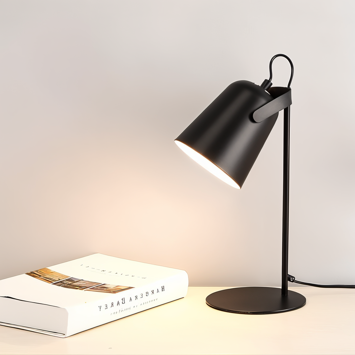 Lampe de bureau noire moderne éclairant un livre sur une table en bois clair, design minimaliste, éclairage intérieur, décoration contemporaine.