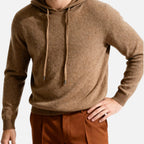 Homme portant un pull à capuche en laine marron, manches longues, avec un pantalon marron. Mode automne-hiver, style décontracté et élégant.