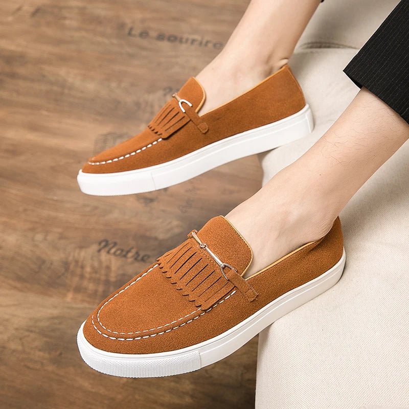 Chaussures mocassins marron en daim pour homme, semelle blanche, style décontracté, sur fond de parquet en bois. Mode masculine élégante.