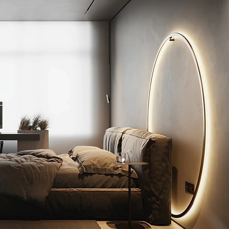 Lit moderne avec tête de lit rembourrée, table de chevet minimaliste, et lampe murale ovale LED dans une chambre contemporaine élégante.