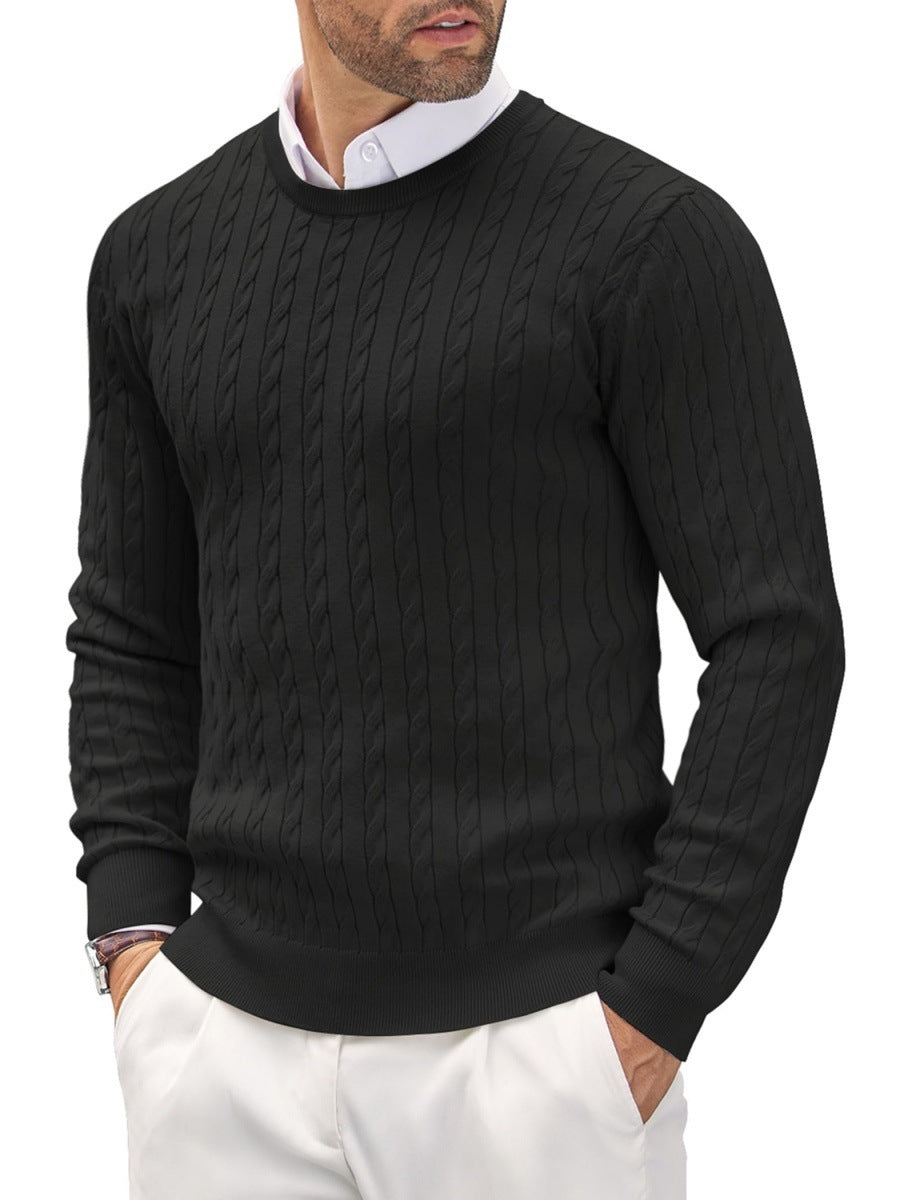 Homme portant un pull noir torsadé élégant, chemise blanche en dessous, pantalon blanc. Mode masculine chic, tenue automne-hiver tendance.