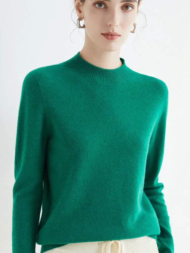 Femme portant un pull vert en cachemire, manches longues, col rond, style élégant et moderne, idéal pour l'automne et l'hiver.