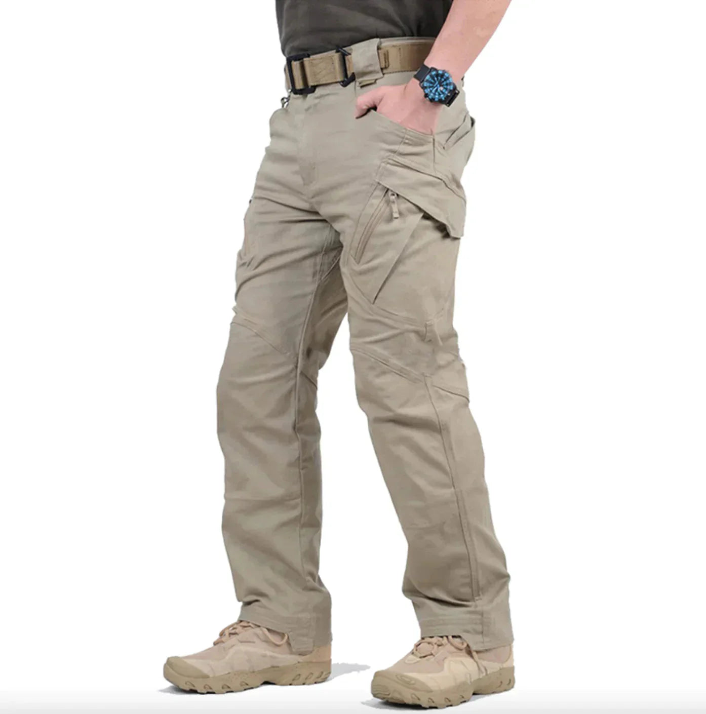 Pantalon cargo beige pour homme, style tactique, avec poches multiples, ceinture ajustée, montre noire, chaussures robustes. Mode outdoor pratique.
