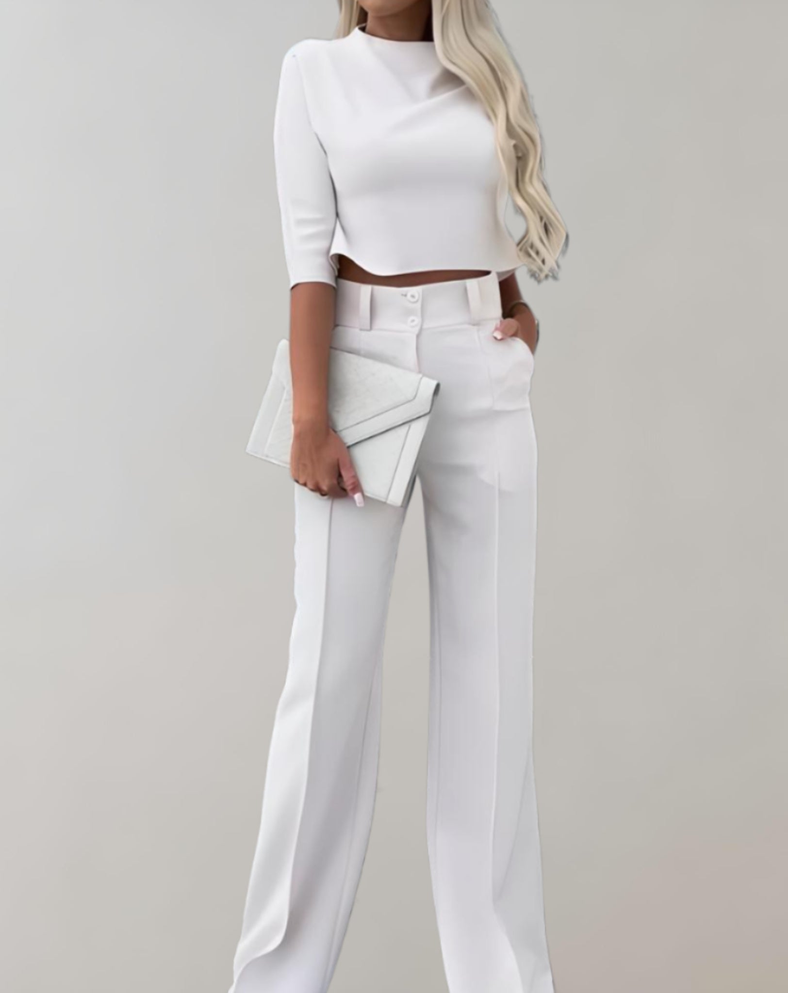 Femme en tenue élégante blanche, portant un ensemble pantalon et haut court, tenant une pochette assortie. Mode chic, style minimaliste.